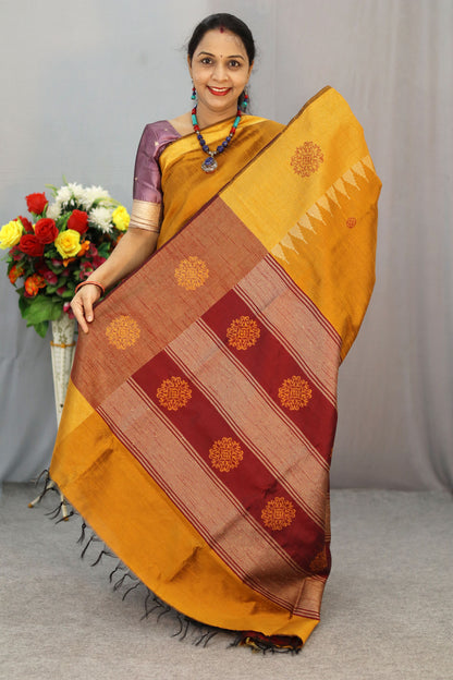 "Elegant orange and turmeric yellow hand-woven saree, crafted beautifully."