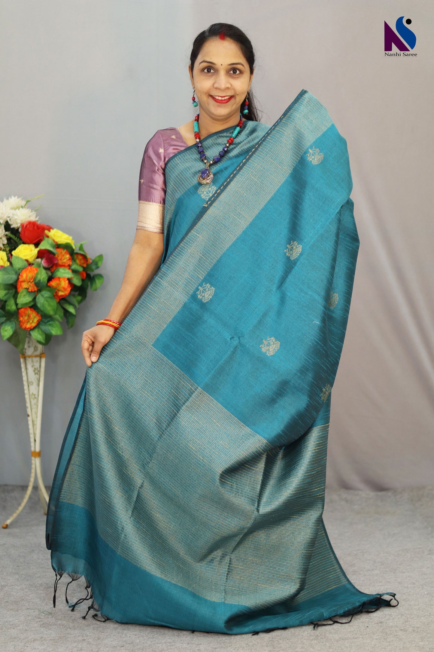 A handloom saree featuring buta work, contrast pallu and turquoise tones
