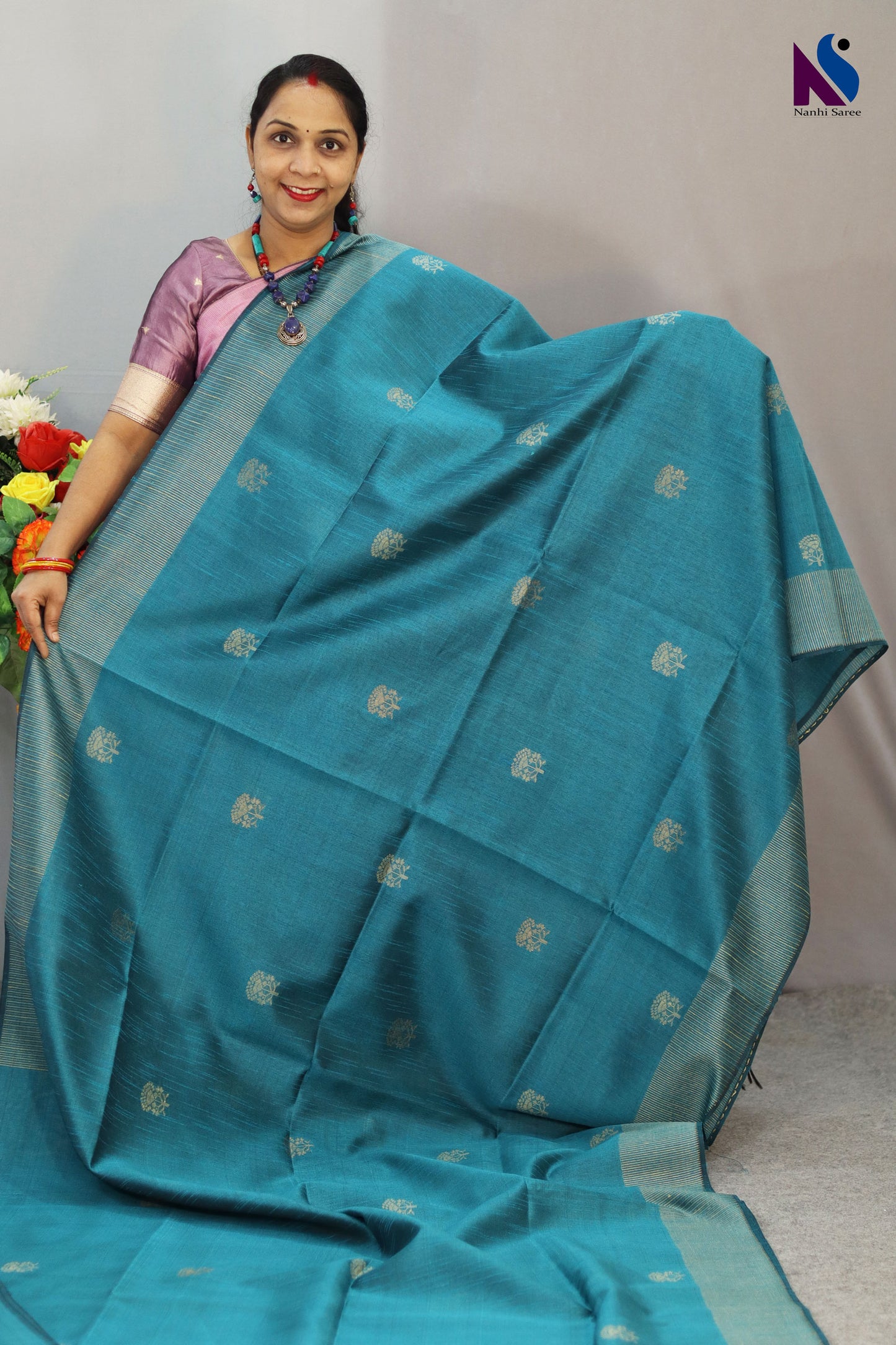 A handloom saree featuring buta work, contrast pallu and turquoise tones