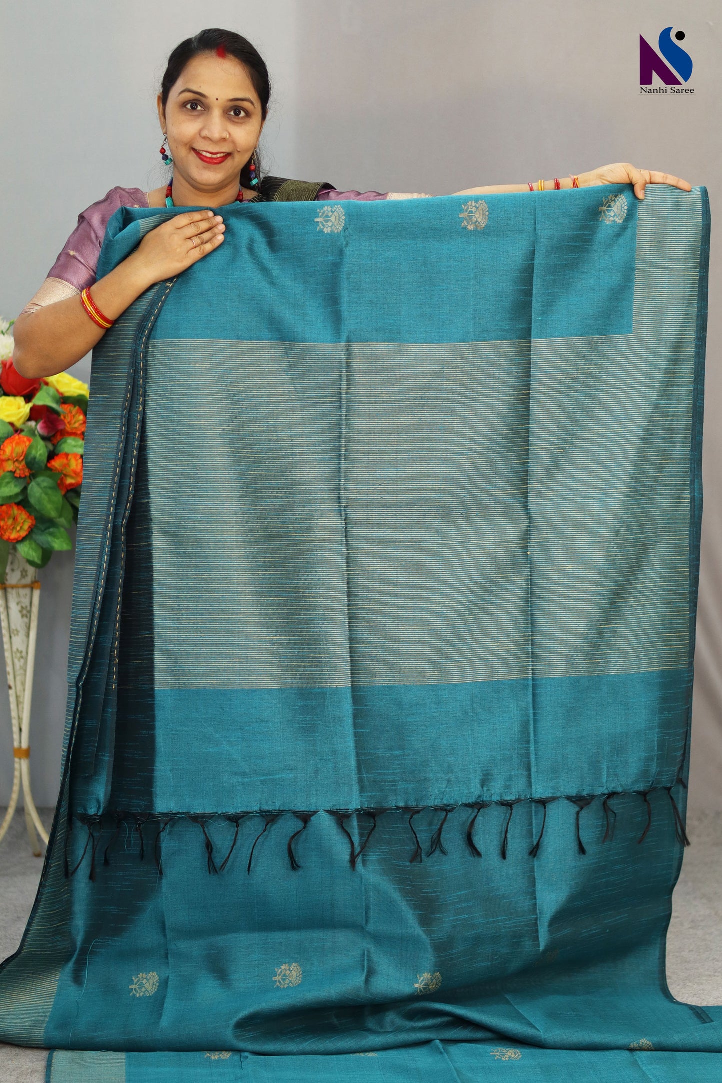 A handloom saree featuring buta work, contrast pallu and turquoise tones