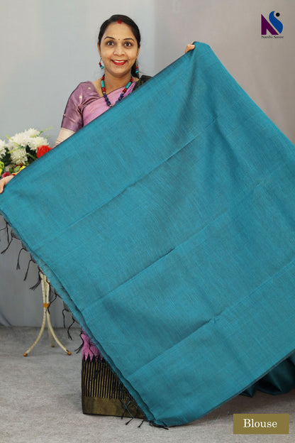 A handloom saree featuring buta work, contrast pallu and turquoise tones